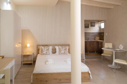 1 dormitorio con 1 cama grande y 1 mesa en Poseidon Apartments and Villas by the Sea, en Sounio
