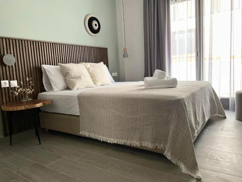 a bedroom with a large bed with a wooden headboard at Αura Luxury Apartments in Ierissos
