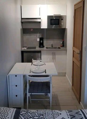 une petite cuisine avec une table et un micro-ondes dans l'établissement Studio HAPPY'Home tout confort proche Rouen, à Saint-Étienne-du-Rouvray