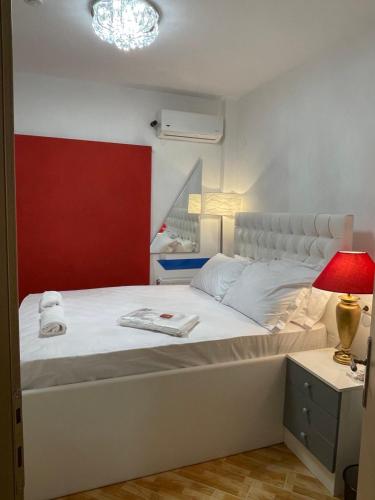 um quarto com uma cama branca e uma parede vermelha em Villa Jogia (πρώην ονομασία Villa Chanel em Marathos