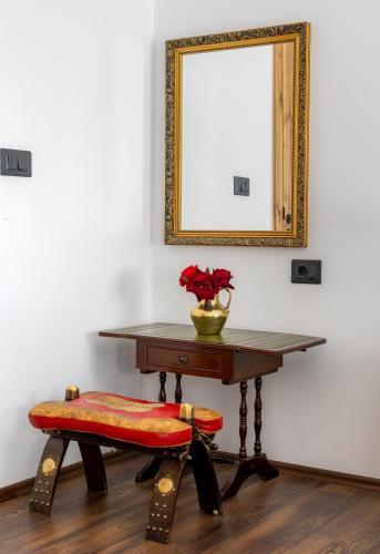 a table with a chair and a mirror on a wall at Doa Boutique Hotel in Peje
