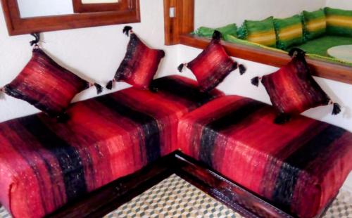 2 bedden met rode kussens in een kamer bij Dar Sakina in Chefchaouene