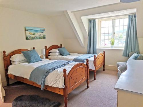 a bedroom with two beds and a window at Harbour House Holiday Home in Porlock