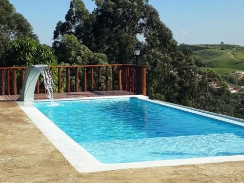 a swimming pool with a water fountain at Chalé Bela Vista in Serra Negra