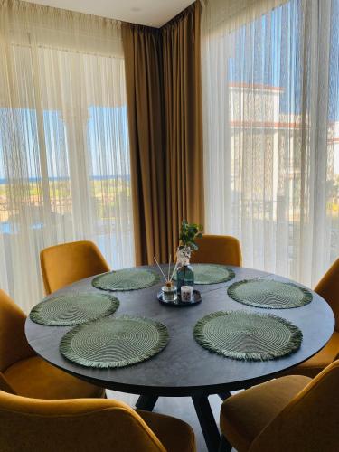 a dining room table with green plates on it at Sea Magic Royal Apartments in Khóti Nisí