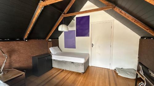 a small room with a bed in a attic at Hostel Hug Brasil in Curitiba