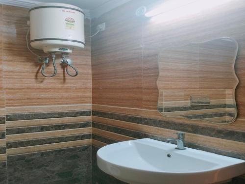 Hotel Maxx في لاكناو: حمام مع حوض واضاءة على الحائط