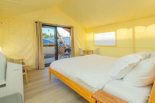 a bedroom with a large bed with a view of the ocean at Urban Oasis Luxe Glamping with King Bed & BBQ in Glendora