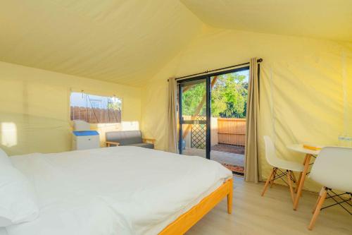 1 dormitorio con cama, escritorio y ventana en Urban Oasis Luxe Glamping with King Bed & BBQ en Glendora
