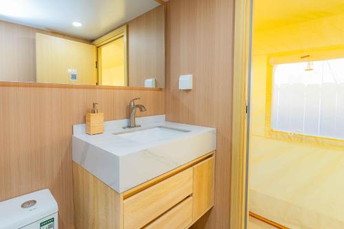a bathroom with a white sink and a shower at Urban Oasis Luxe Glamping with King Bed & BBQ in Glendora