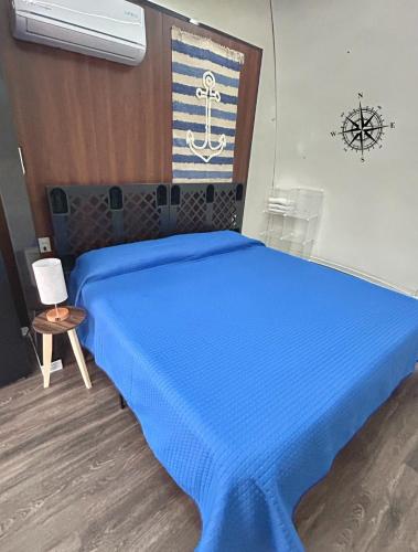a bedroom with a blue bed with a wooden headboard at Iglú Sparrow vista al cielo in Barra de Navidad