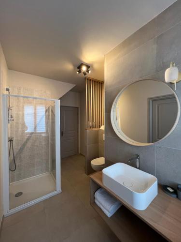 uma casa de banho com um lavatório, um chuveiro e um espelho. em MUSCAT - Bel appartement rénové récemment - au pied du vignoble - parking gratuit em Riquewihr