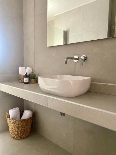 a bathroom with a white sink and a mirror at Αura Luxury Apartments in Ierissos