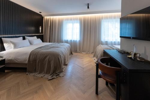 Habitación de hotel con cama grande y escritorio. en Gentle Hide Designhotel, en Salzburgo