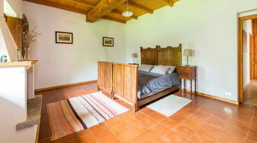 a bedroom with a bed with a wooden bed frame at Ca' Becca-Bioglio in Bioglio