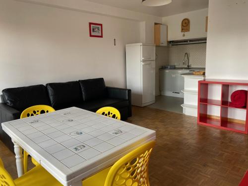 - un salon avec un canapé noir, une table et des chaises dans l'établissement Studio Orcières Merlettes Le Christiana, à Orcières