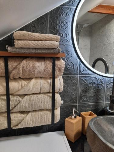 Una pila de toallas en un estante en un baño. en Vintage Four katusekorter, en Haapsalu