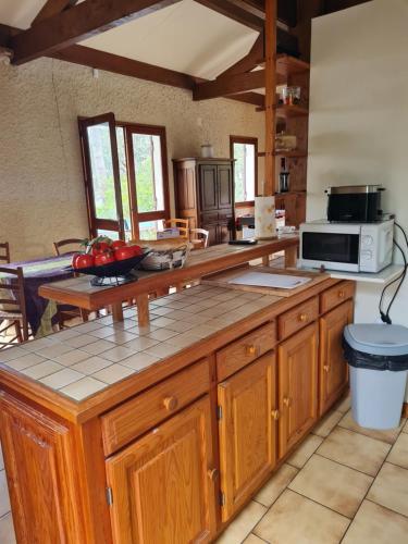 - une cuisine avec des placards en bois et un four micro-ondes dans l'établissement Grande maison familiale, à Lacanau