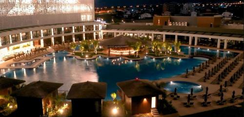 a large swimming pool in a building at night at Grand Sapphire 107 Amazing 1 Bedroom Apartment By MyGuest Cyprus in Iskele