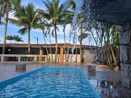 a swimming pool with a water fountain at Casarão Pertinho da Praia in Bertioga