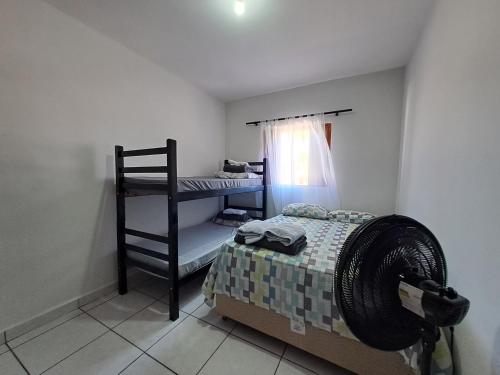 a small bedroom with a bed and a ladder at Casarão Pertinho da Praia in Bertioga