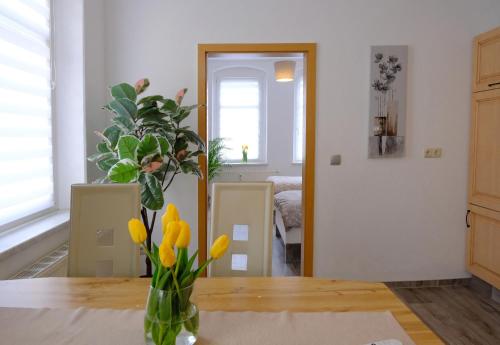 eine Vase mit gelben Blumen auf einem Tisch in der Unterkunft Urlaub nicht nur für Monteure "K1" in Gera