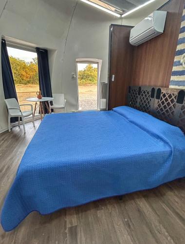 a large bed in a room with a blue bedspread at Iglú Sparrow vista al cielo in Barra de Navidad