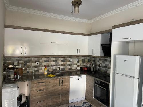 a kitchen with white cabinets and a white refrigerator at Holistic Balance little villa 
