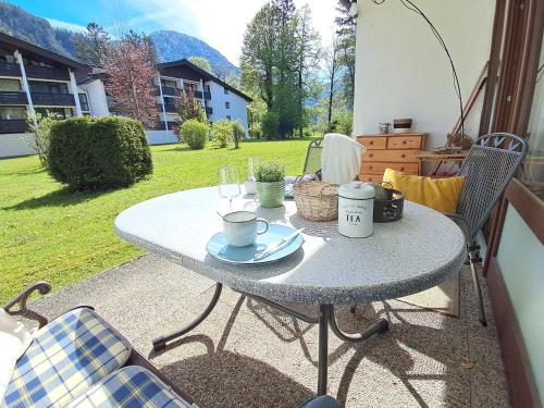 a table with cups and plates on a patio at Appartement mit Hallenbad in Sankt Martin bei Lofer