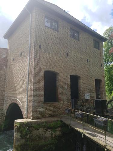 a large brick building with a tunnel in it at Gîte du Moulin Pidoux in Hallines