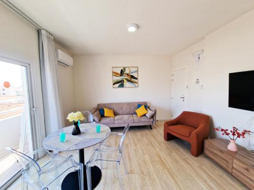 a living room with a couch and a table at Kitieos Central Apartment with Sea View in Larnaca