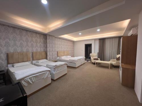 a hotel room with two beds and two chairs at Lara Hotel in Duhok