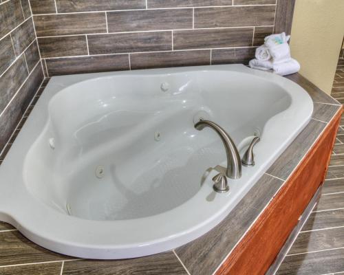 a bath tub in a bathroom with a sink at Comfort Suites Plymouth near US-30 in Plymouth