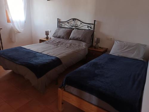 um quarto com 2 camas e lençóis azuis em Montana retreat em Alora