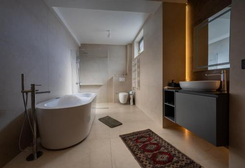 ein Badezimmer mit einer großen Badewanne und einem Waschbecken in der Unterkunft Doa Boutique Hotel in Peja