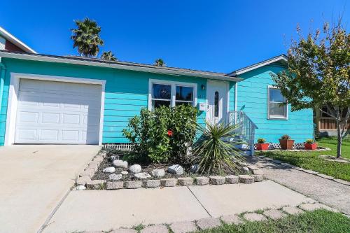 a blue house with a white garage at Cute home near Moody Gardens and Pet Friendly in Galveston