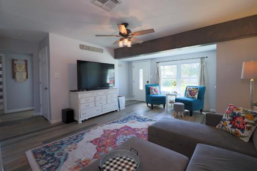 a living room with a couch and a flat screen tv at Cute home near Moody Gardens and Pet Friendly in Galveston