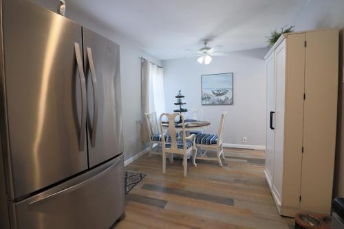 a kitchen with a refrigerator and a table with chairs at Cute home near Moody Gardens and Pet Friendly in Galveston
