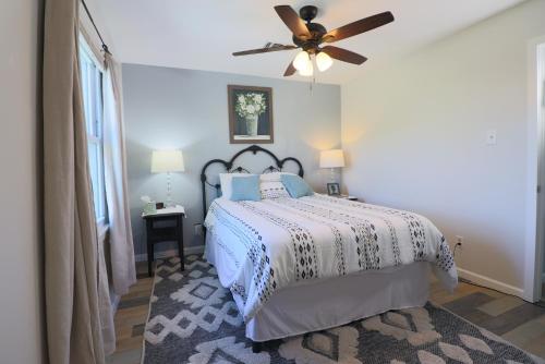 a bedroom with a bed with a ceiling fan at Cute home near Moody Gardens and Pet Friendly in Galveston