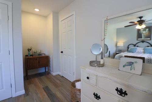 a bedroom with a bed and a mirror on a dresser at Cute home near Moody Gardens and Pet Friendly in Galveston