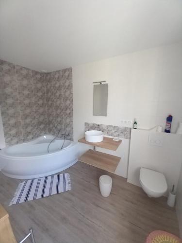 uma casa de banho com uma banheira, um WC e um lavatório. em La Demeure d'Alexandra em Cholet