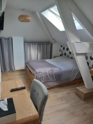 - une chambre avec un lit et un bureau avec une chaise dans l'établissement La Demeure d'Alexandra, à Cholet