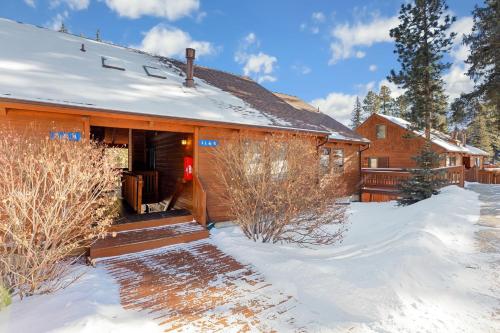 a cabin in the snow with a porch at Creekside Suites 01 by Estes Park Condos in Estes Park