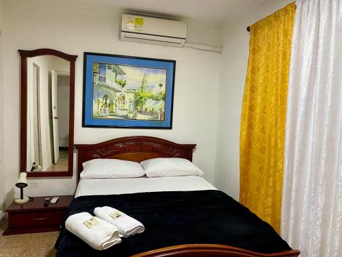 um quarto com uma cama com duas toalhas em Habitación Cerca de aeropuerto em Cartagena de Indias