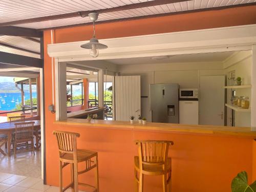 a kitchen and dining room with a bar and chairs at Habitation Bellevue in Sainte-Anne