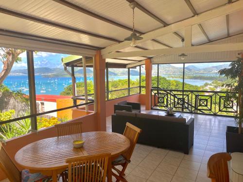 a room with a table and chairs and a view of the ocean at Habitation Bellevue in Sainte-Anne