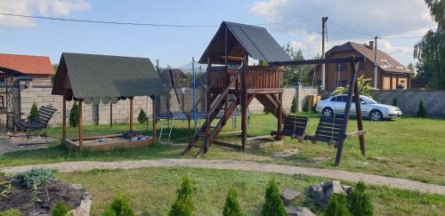 un parque infantil con columpio en un patio en Садиба For Rest en Svityazʼ