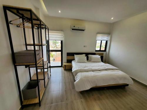 a bedroom with two beds and a spiral staircase at Star Tower in Accra