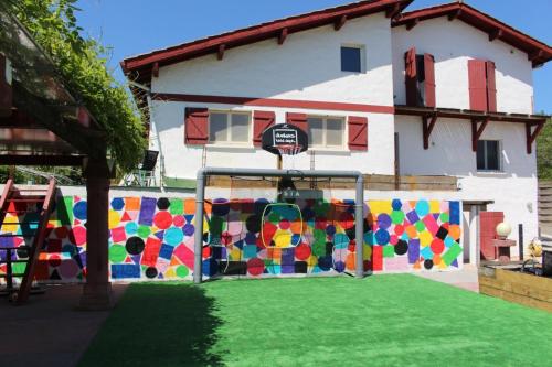a house with a colorful fence and a basketball hoop at Chambre 4 couchages proche du bourg de La Bastide Clairence in Hasparren