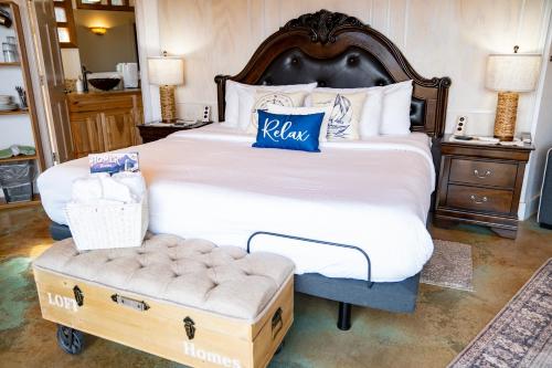 a bedroom with a large bed with a ottoman in front at Homer Inn & Spa in Homer